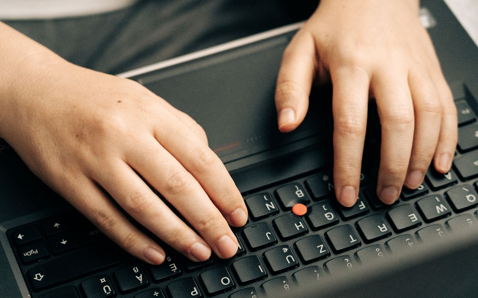 Manos escribiendo código sobre el teclado de un portátil